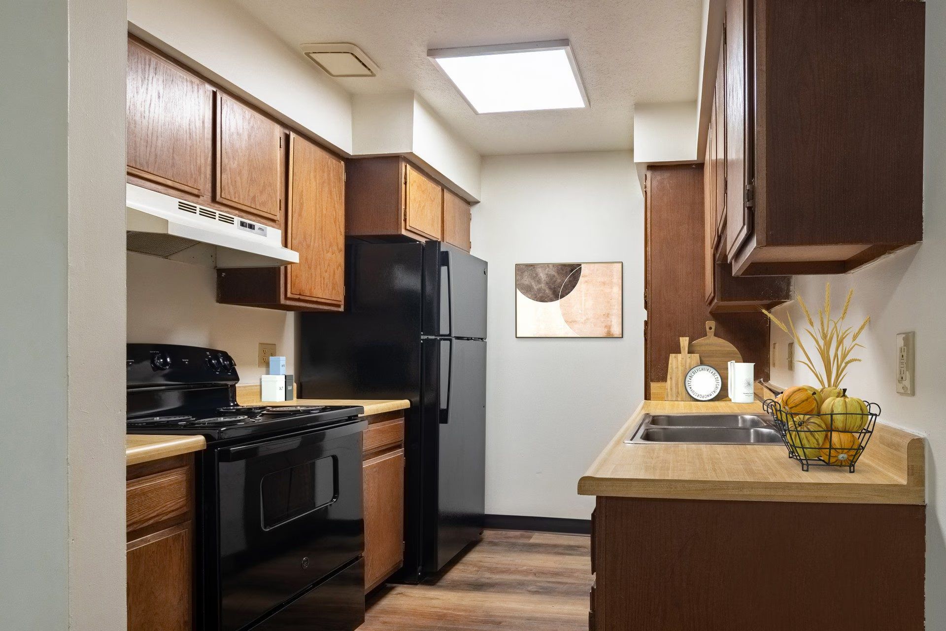 Kitchen with brown cabinets, black appliances, and wooden countertops.