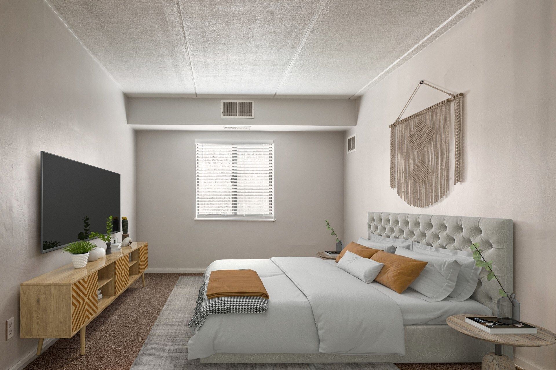 Bedroom with a bed, TV, and decorative wall hanging, neutral colors.