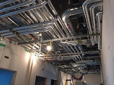 above ceiling services pipework in HSE hospital being insulated by Lagforce insulation services
