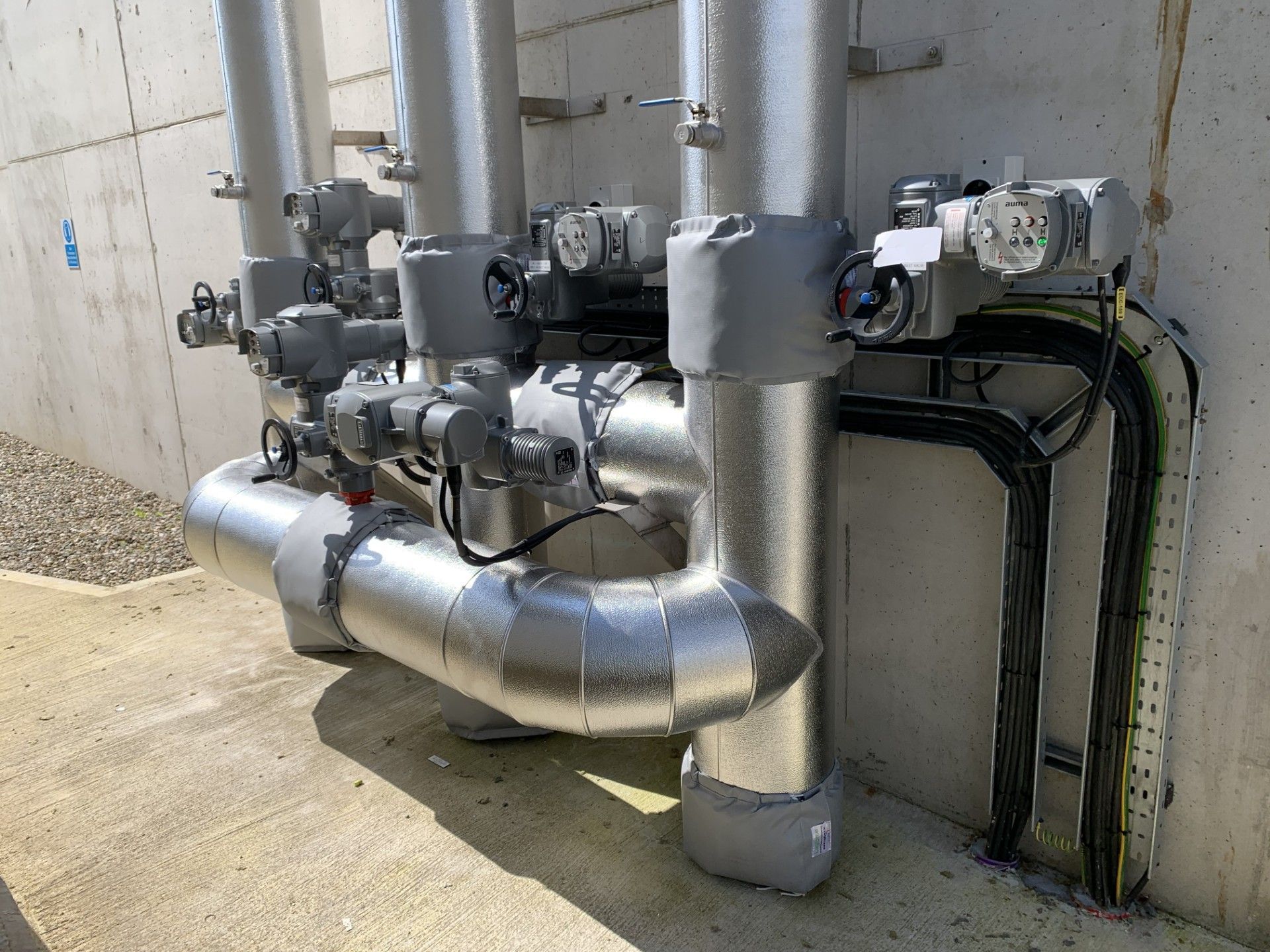 Pipework insulated with fiberglass rockwool sections and clad with aluminium in a waste water treatment facility in Donegal