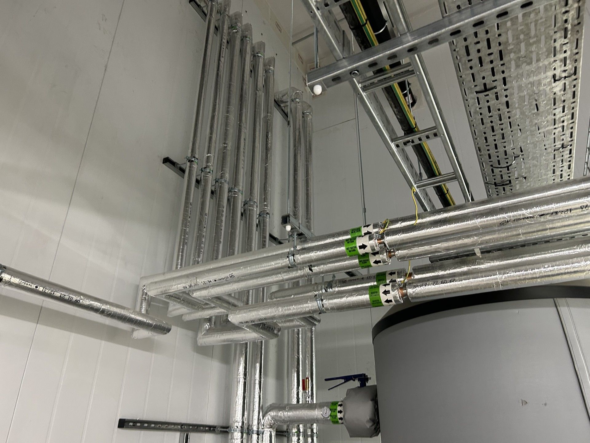 Boiler house water services pipework insulated with foiled fiberglass by Lagforce in Nass in Kildare