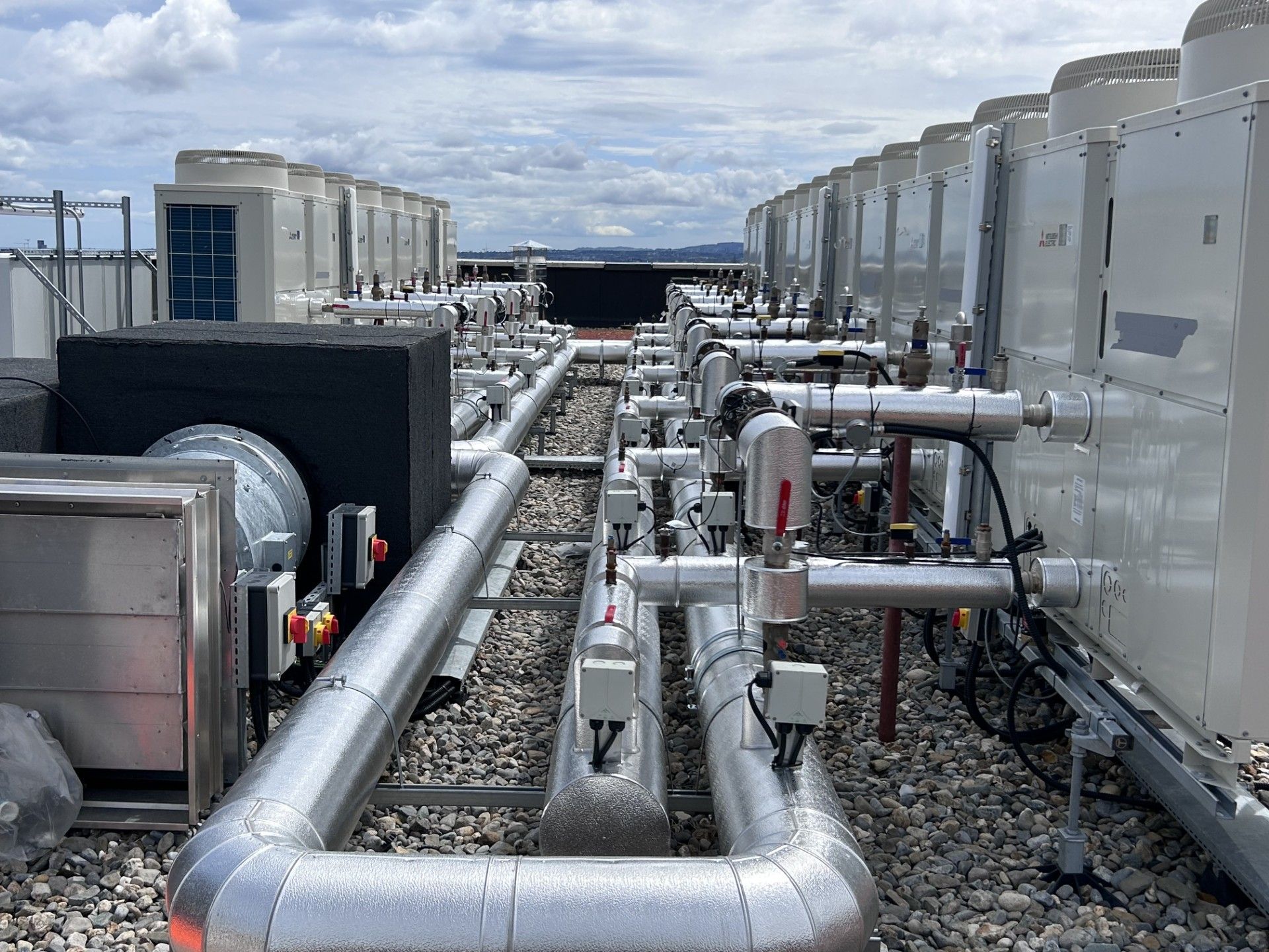 Industrial pipework system insulated with fiberglass and clad with aluminium on a large LTHW heating system in Dublin