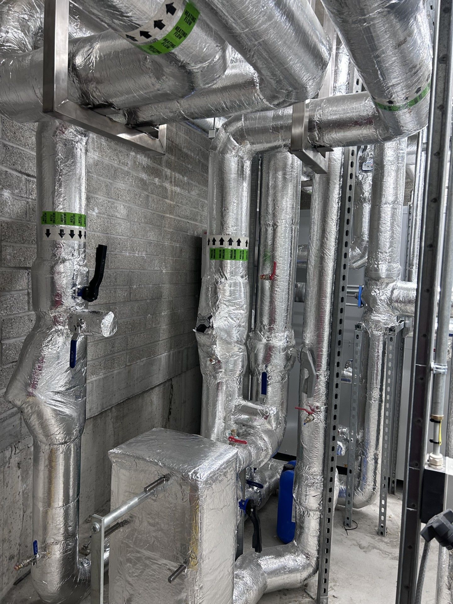 Industrial pipework with isolation valves, pumps and heat exchanger insulated with foiled fiberglass by lagforce