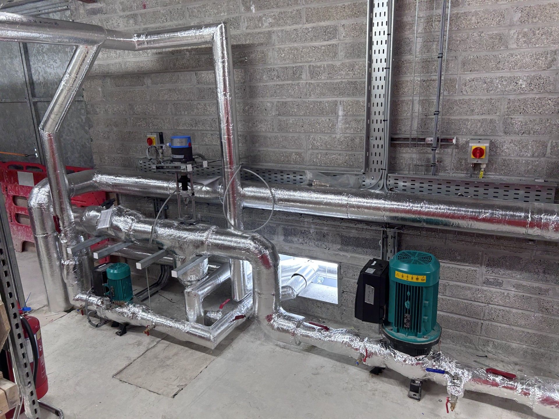 Industrial pipework with circulation pump and dirt separator insulated with foiled fiberglass