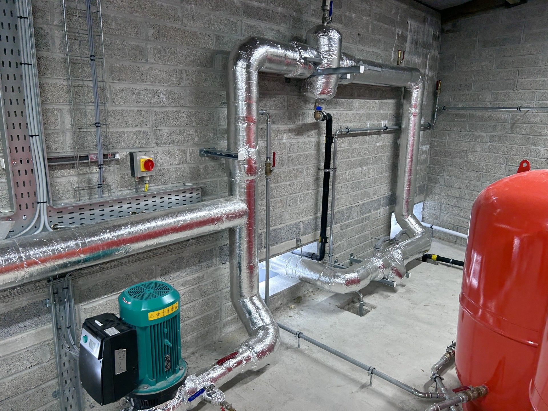 Industrial pipework with circulation pump and dirt separator insulated with foiled fiberglass