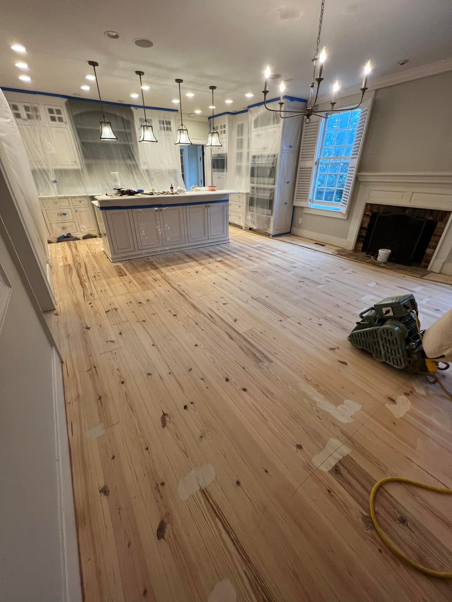 A kitchen with a wooden floor and a fireplace.