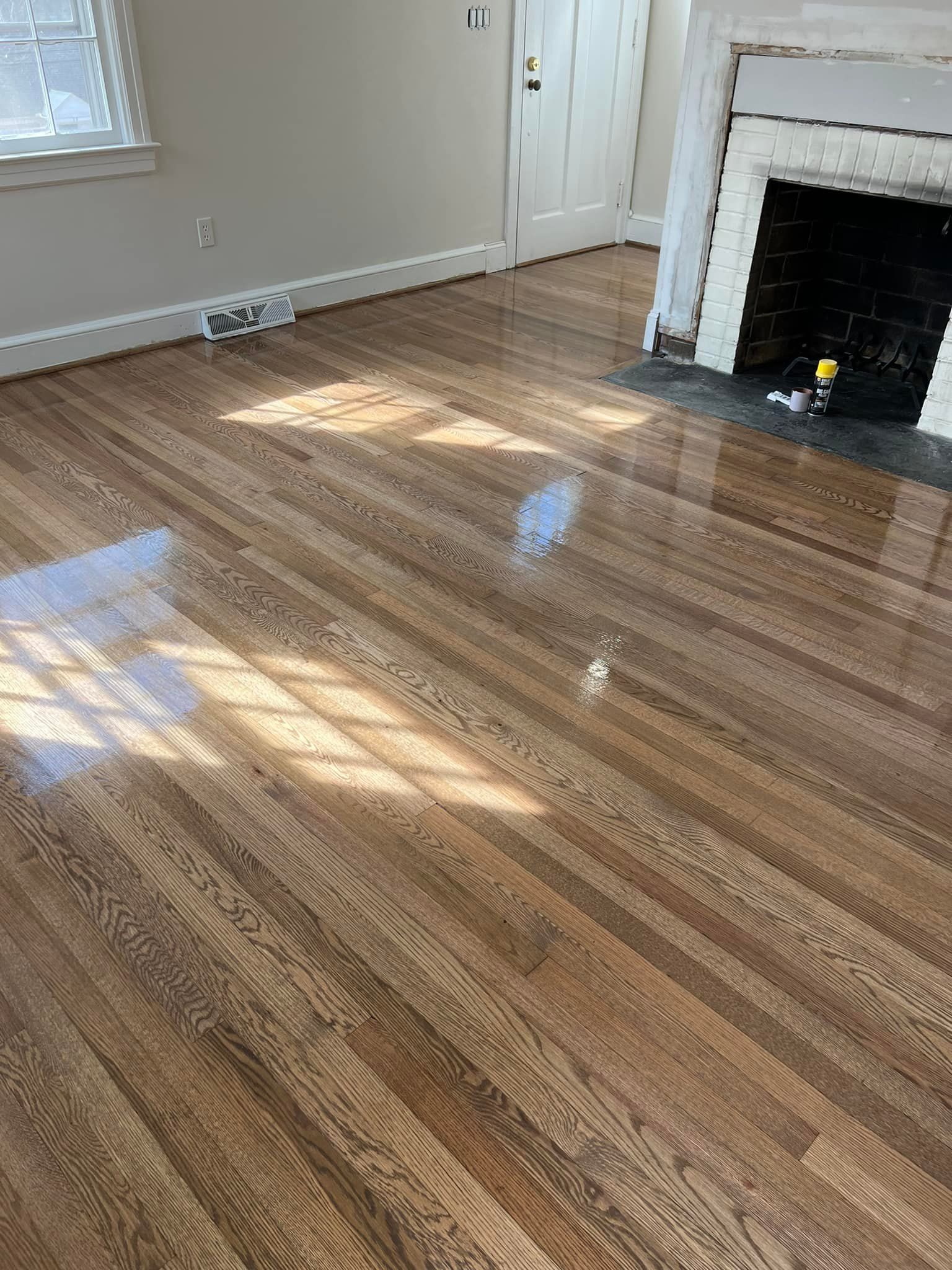 A living room with hardwood floors and a fireplace.