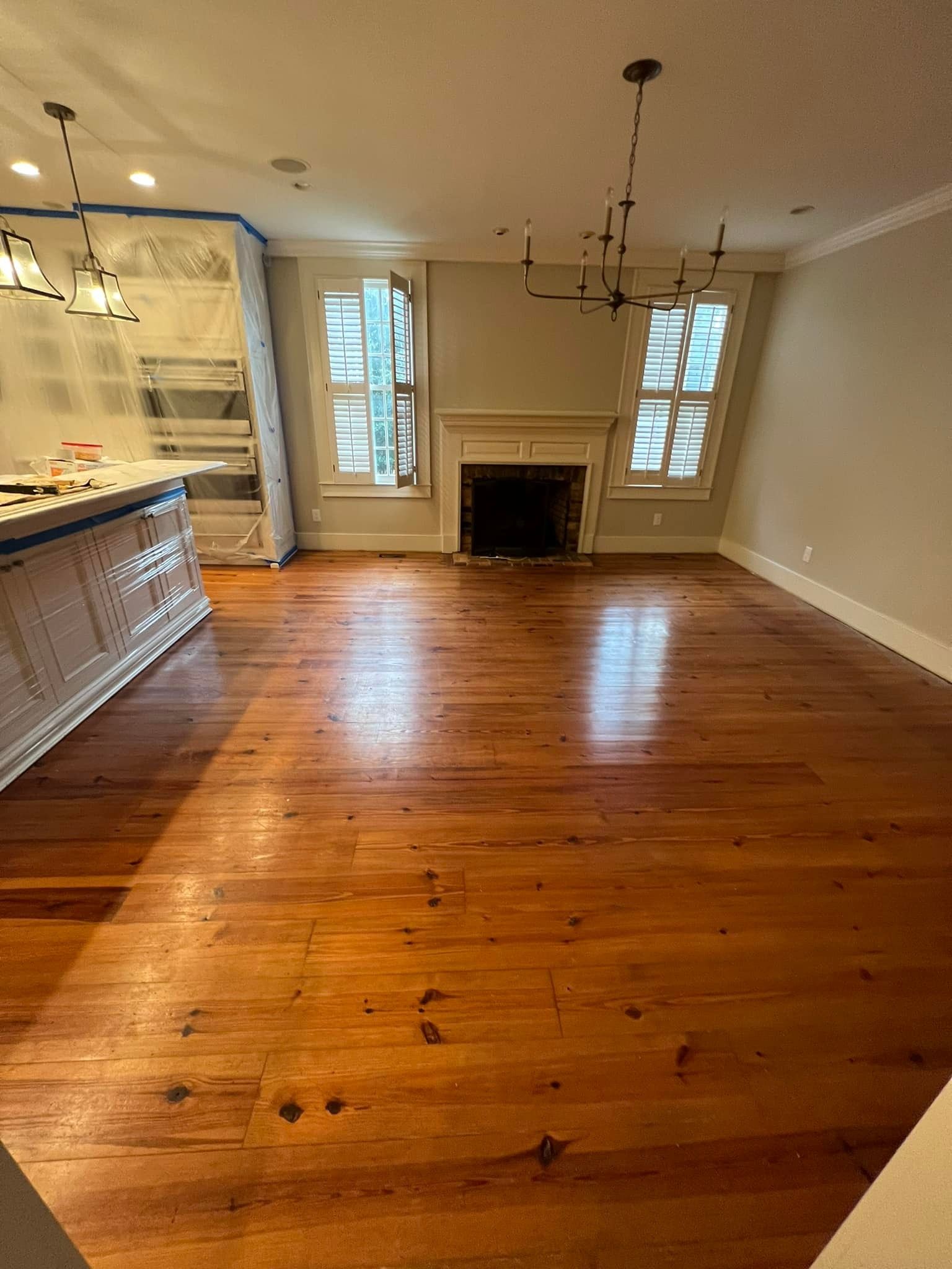 An empty living room with hardwood floors and a fireplace.