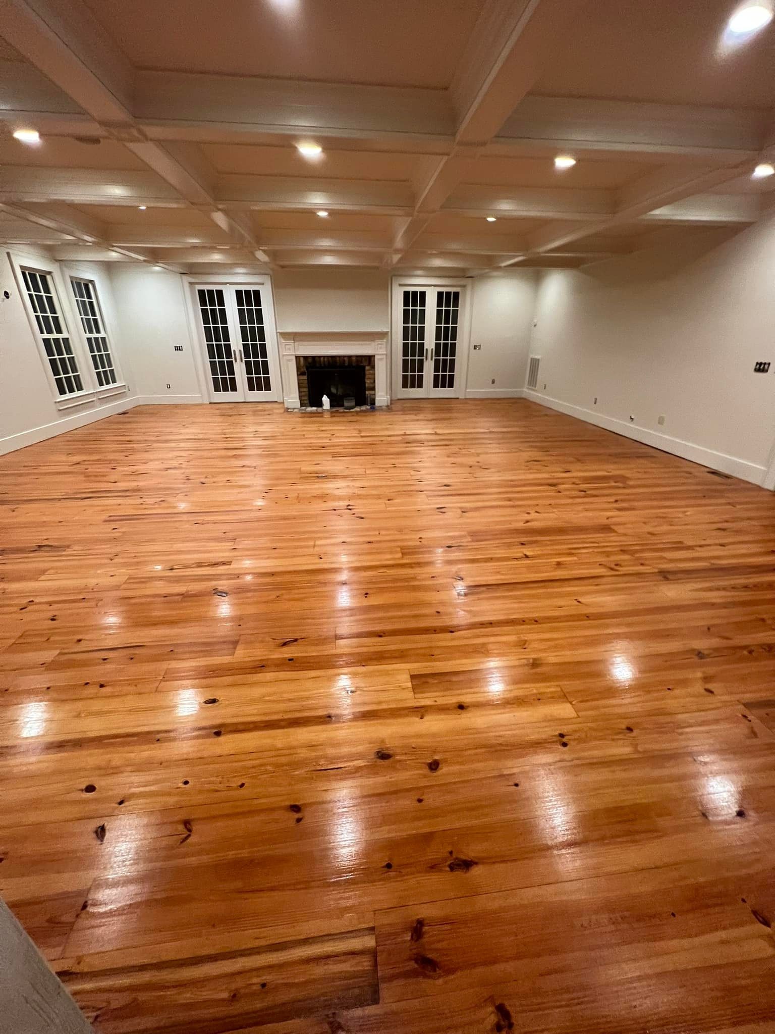 A large room with hardwood floors and a fireplace.