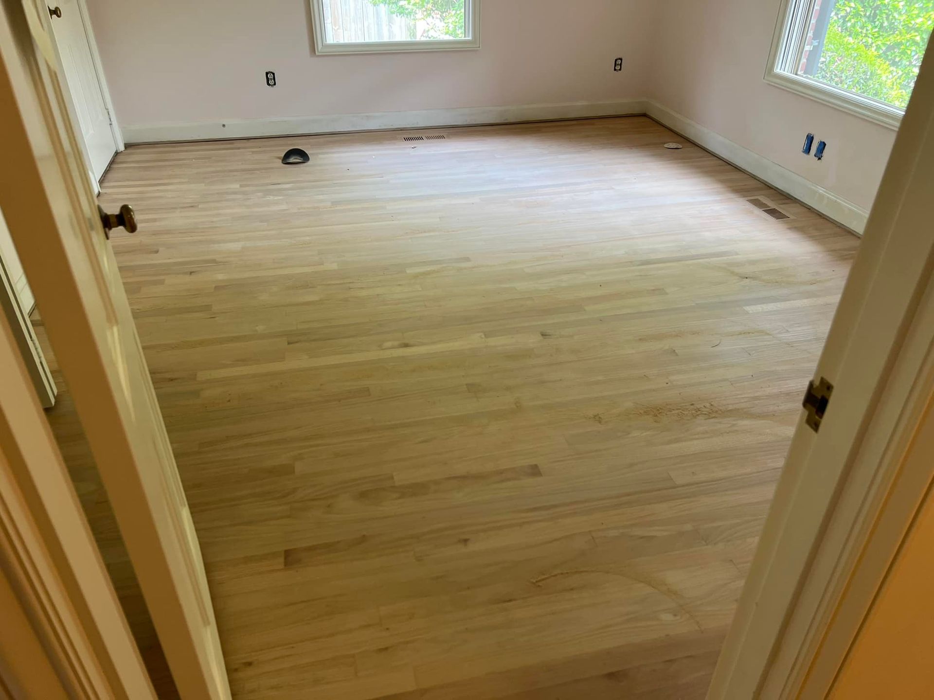 A room with a wooden floor and a window.