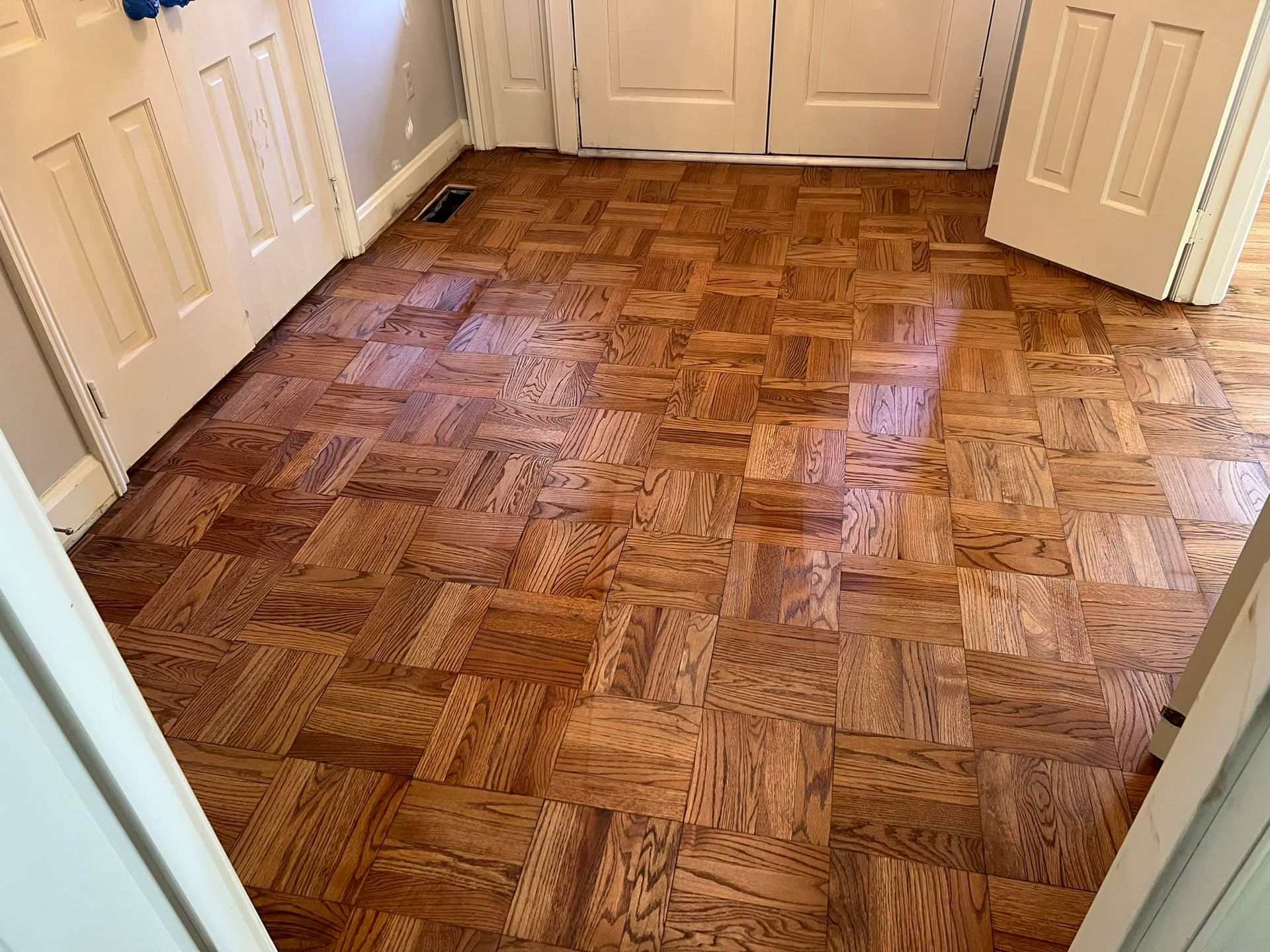 A wooden floor with a herringbone pattern in a room.