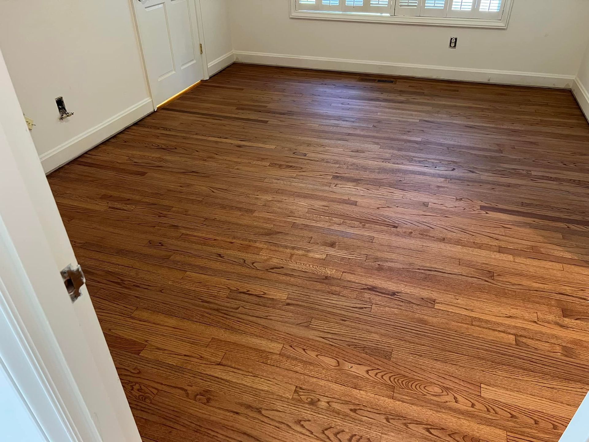 A room with hardwood floors and white walls.