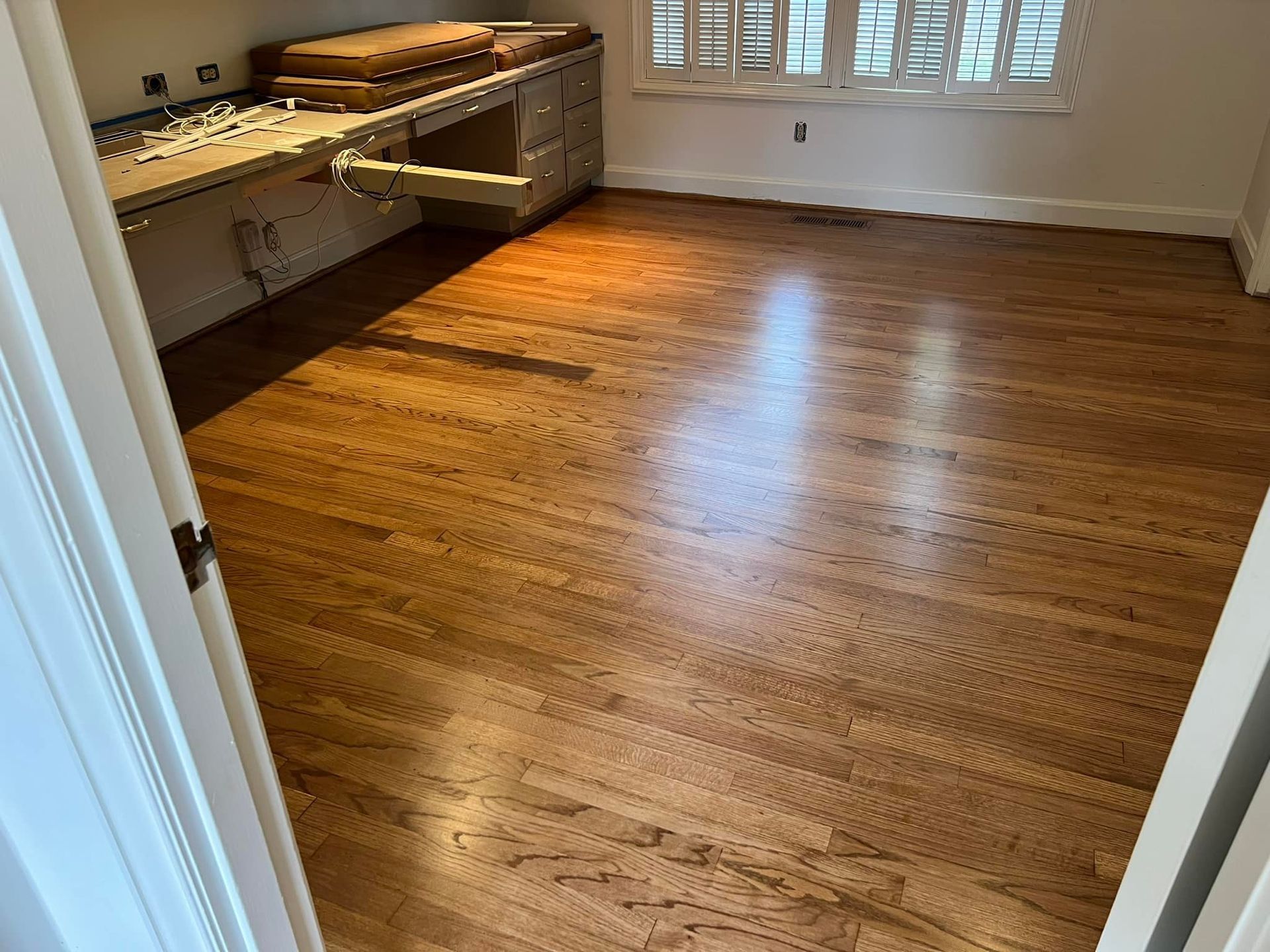 A room with hardwood floors and a desk in it.