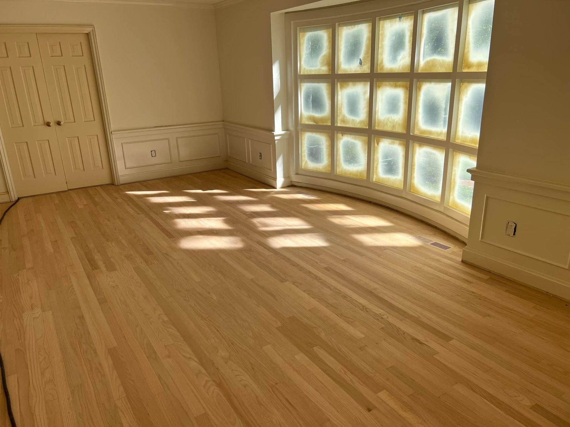 A room with a wooden floor and a large window.