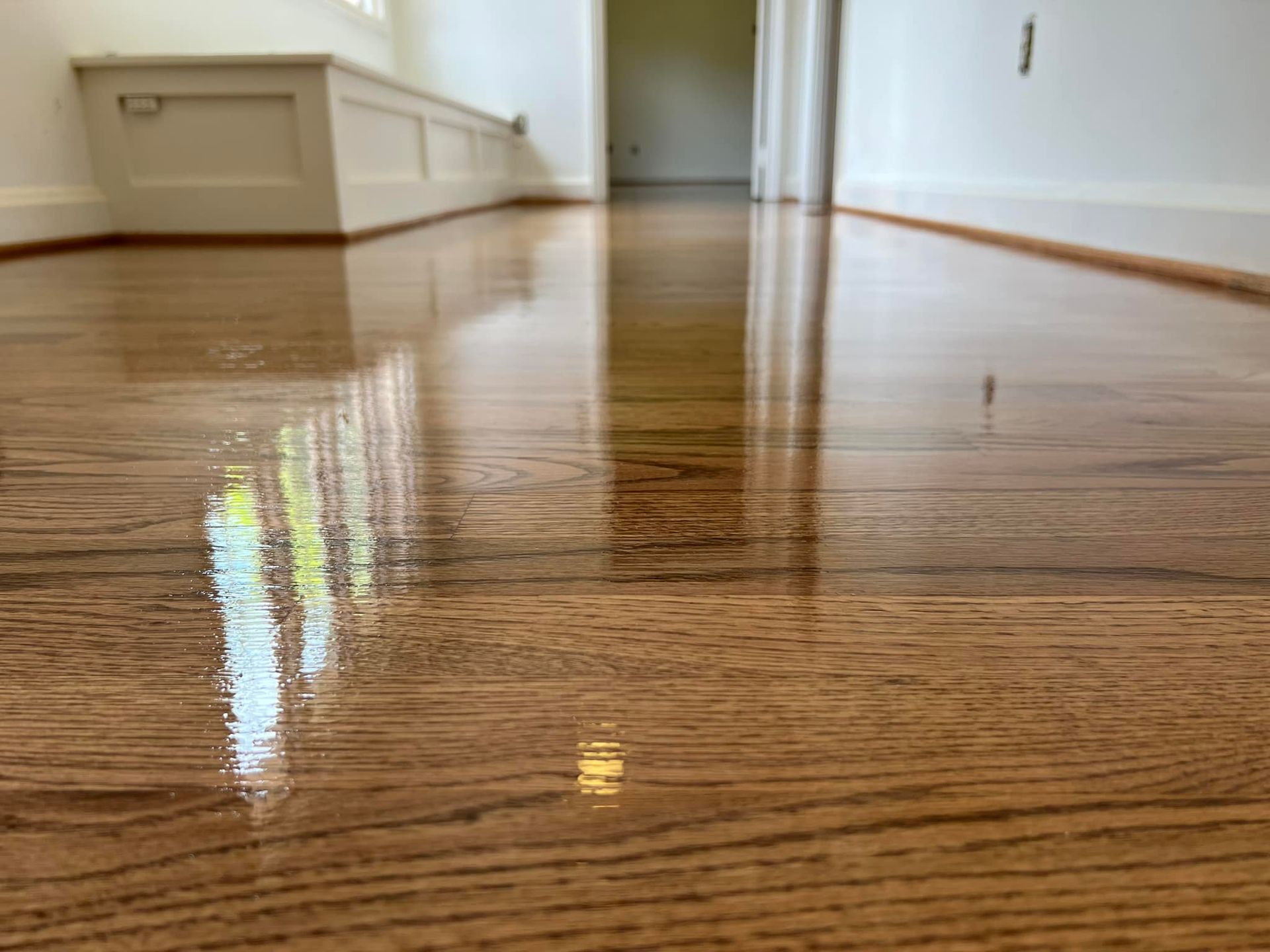 A close up of a wooden floor in a hallway.