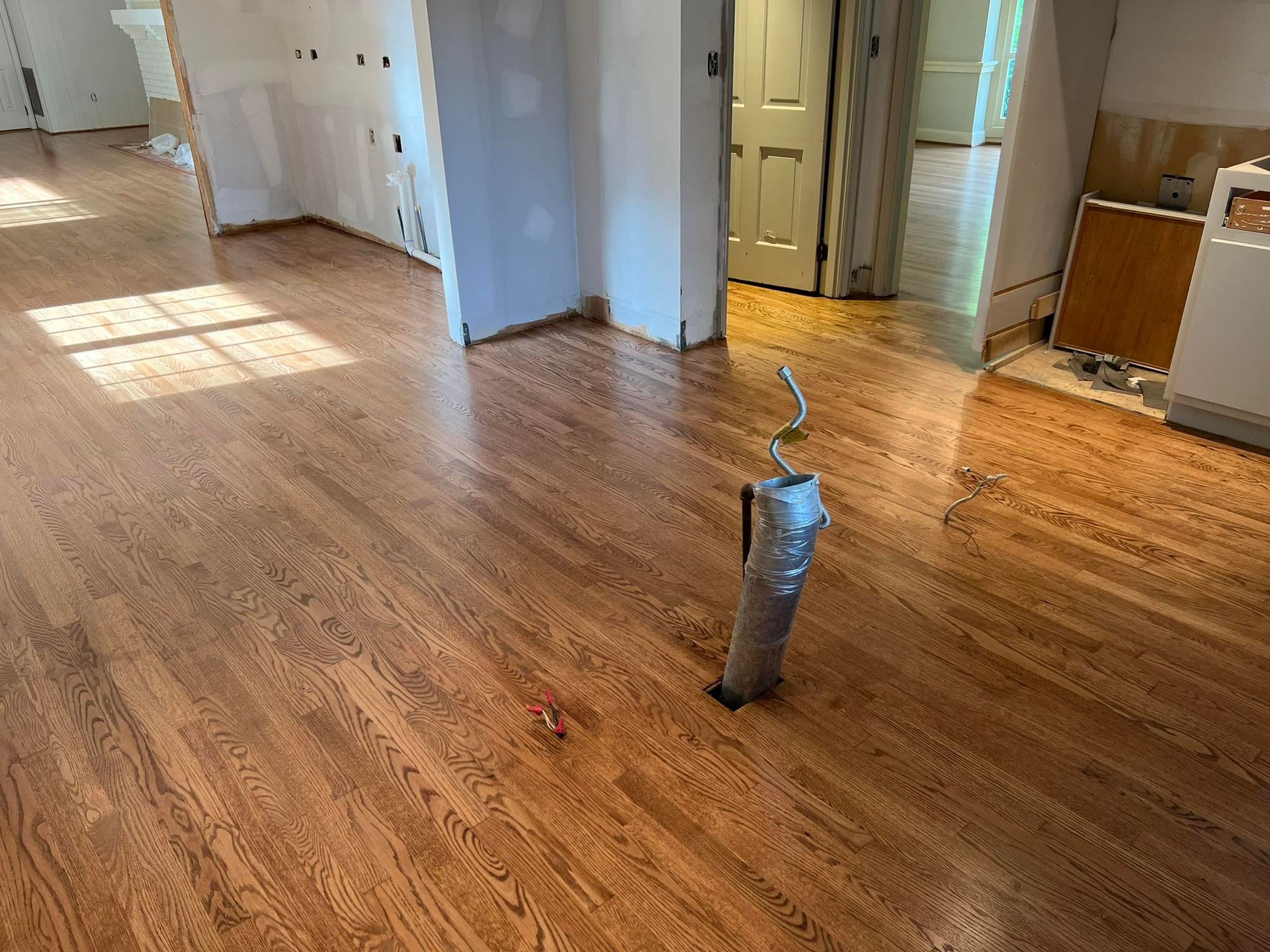 A vacuum cleaner is sitting on a wooden floor in a room.