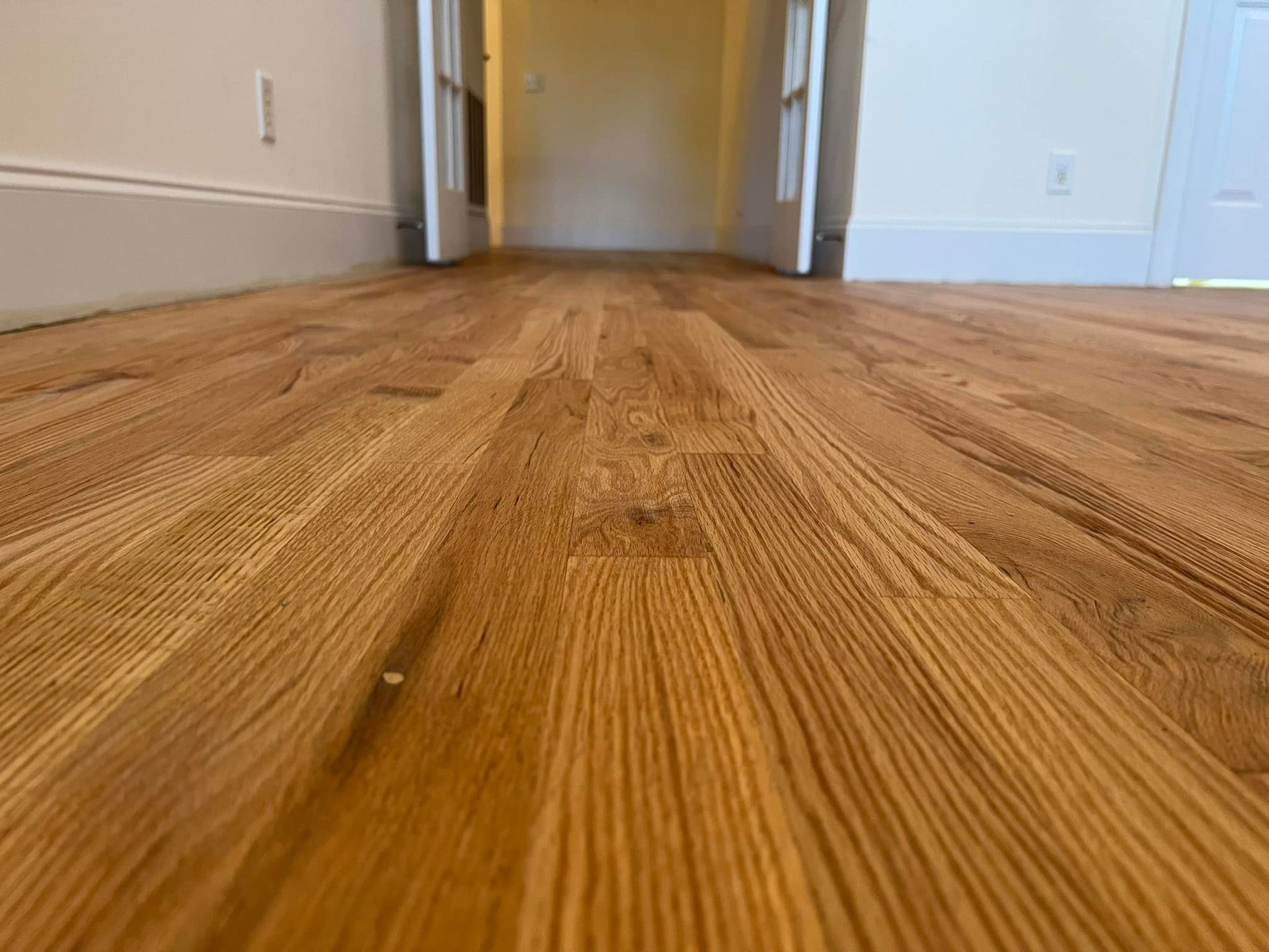 A close up of a wooden floor in an empty room.