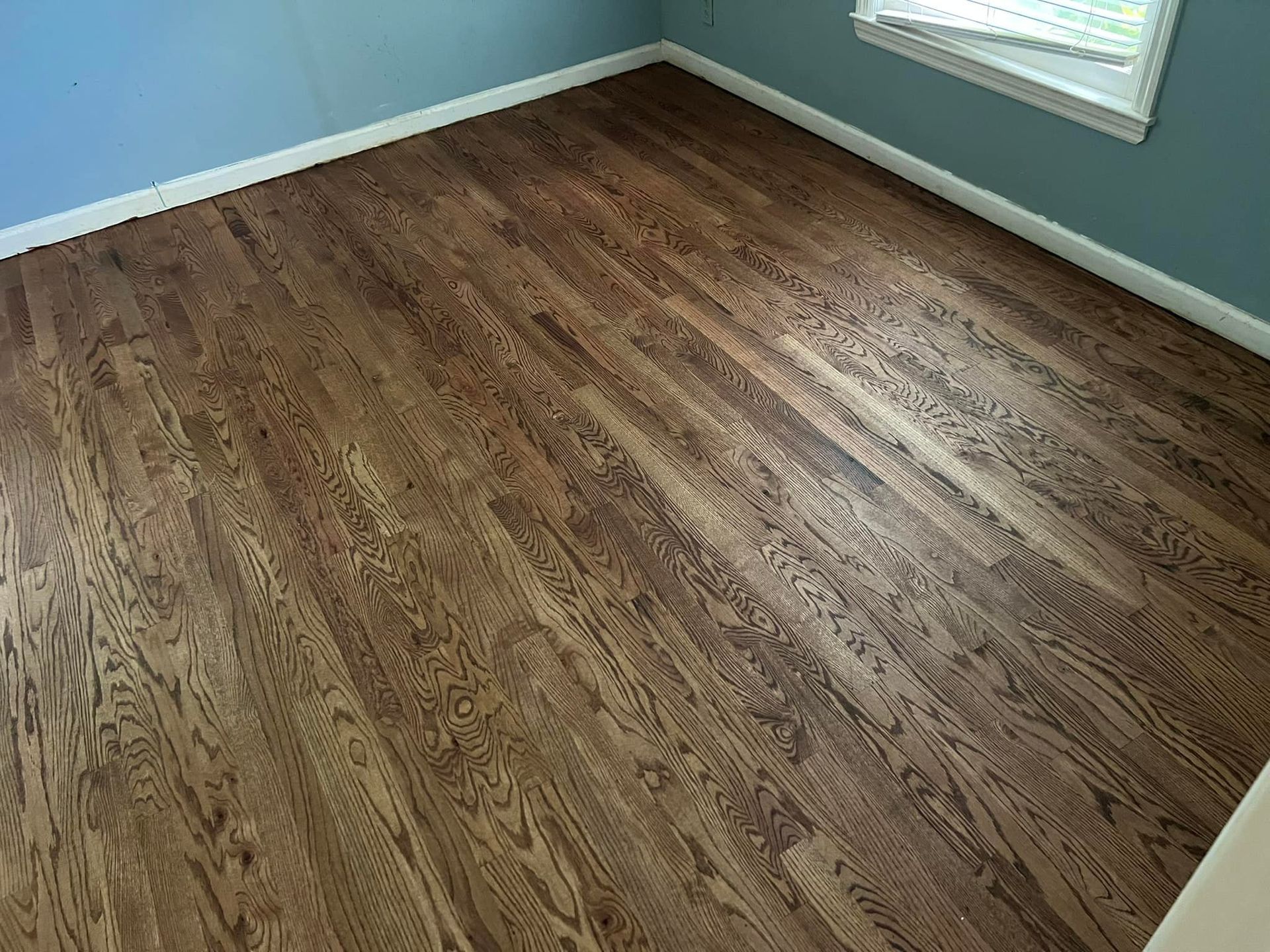 A bedroom with hardwood floors and blue walls.