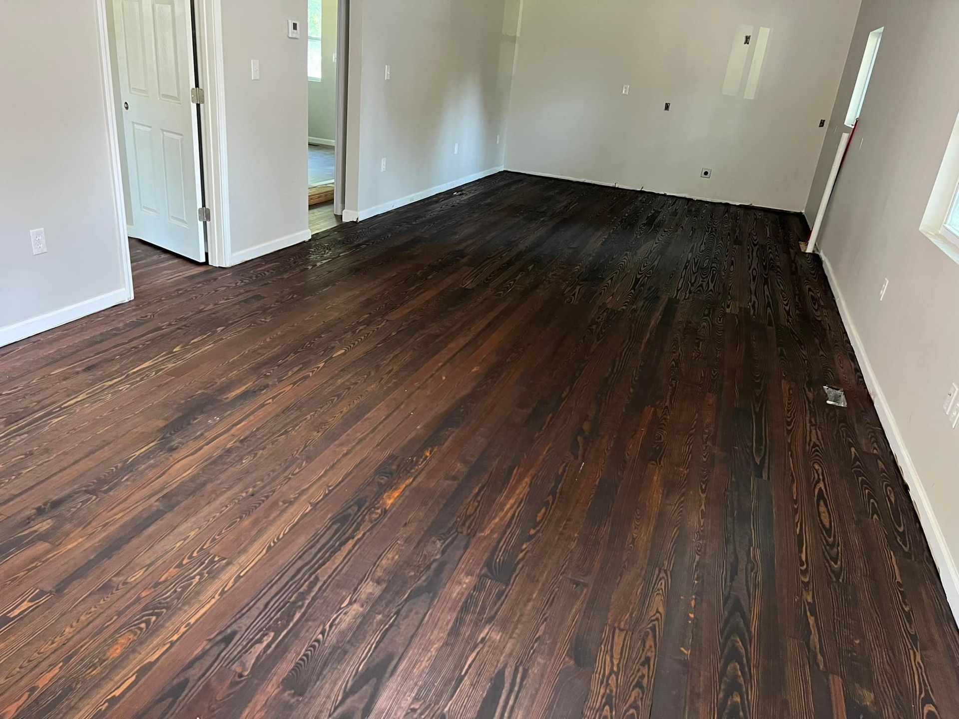 A living room with hardwood floors and white walls.