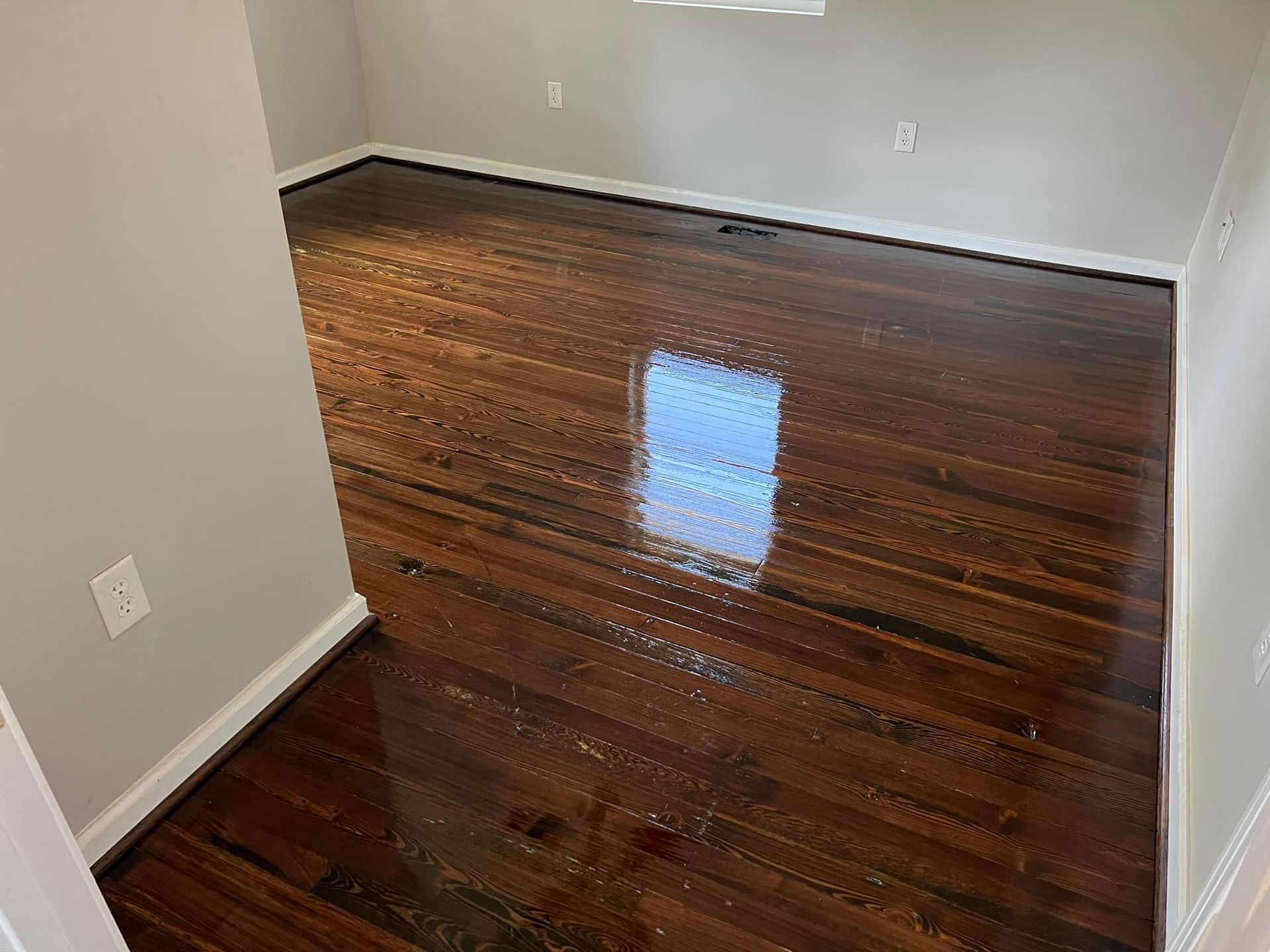 A room with a wooden floor and white walls.