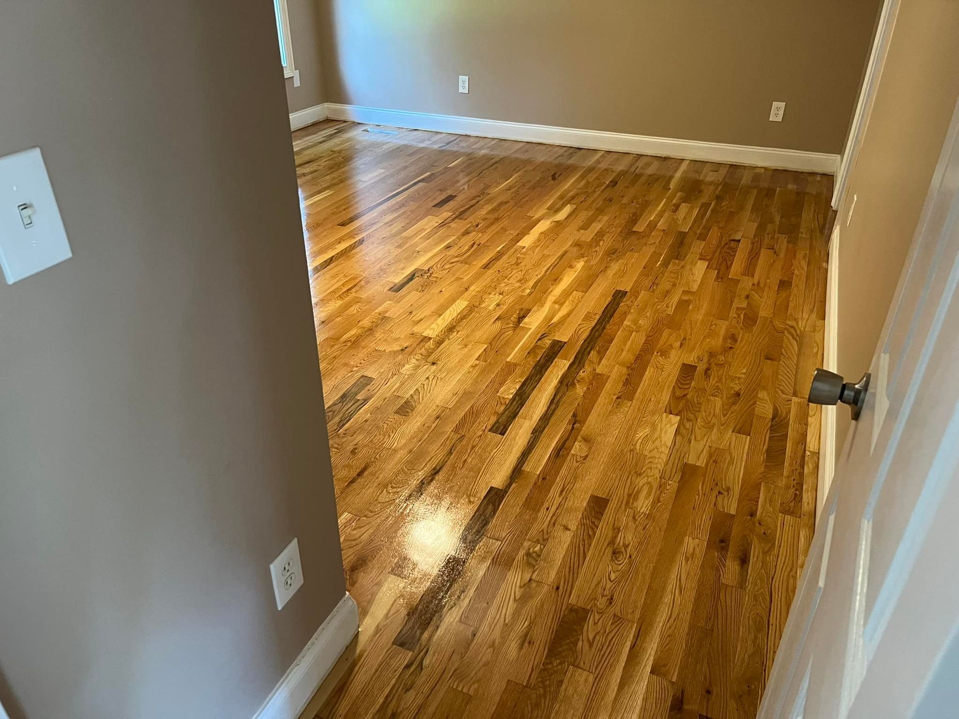 A hallway with hardwood floors in a house.