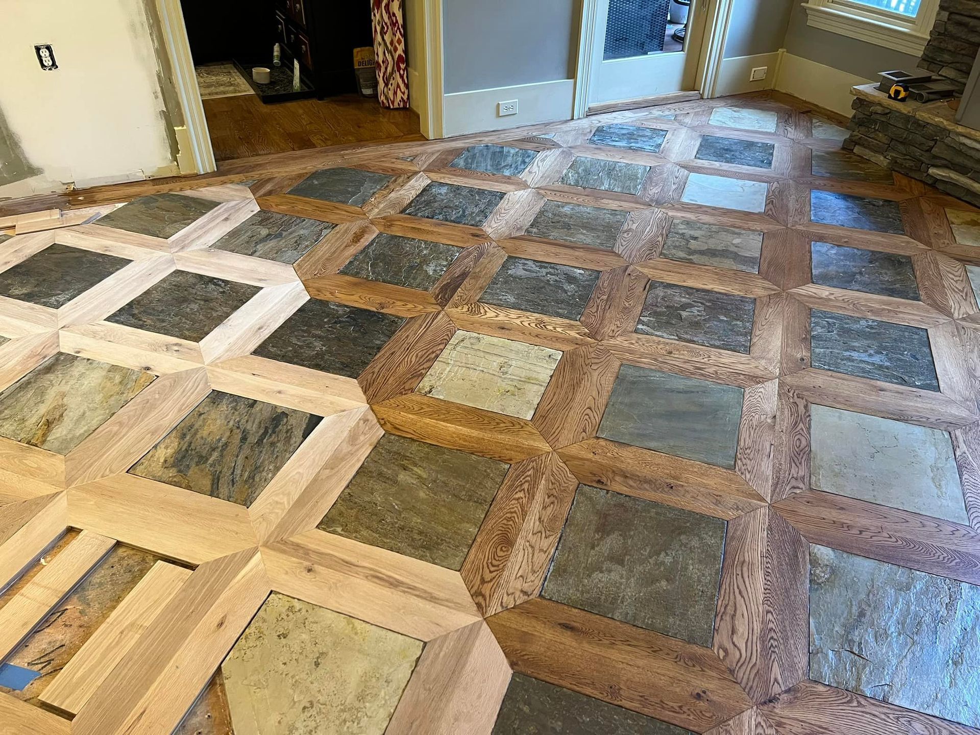 A wooden floor with tiles on it in a room.