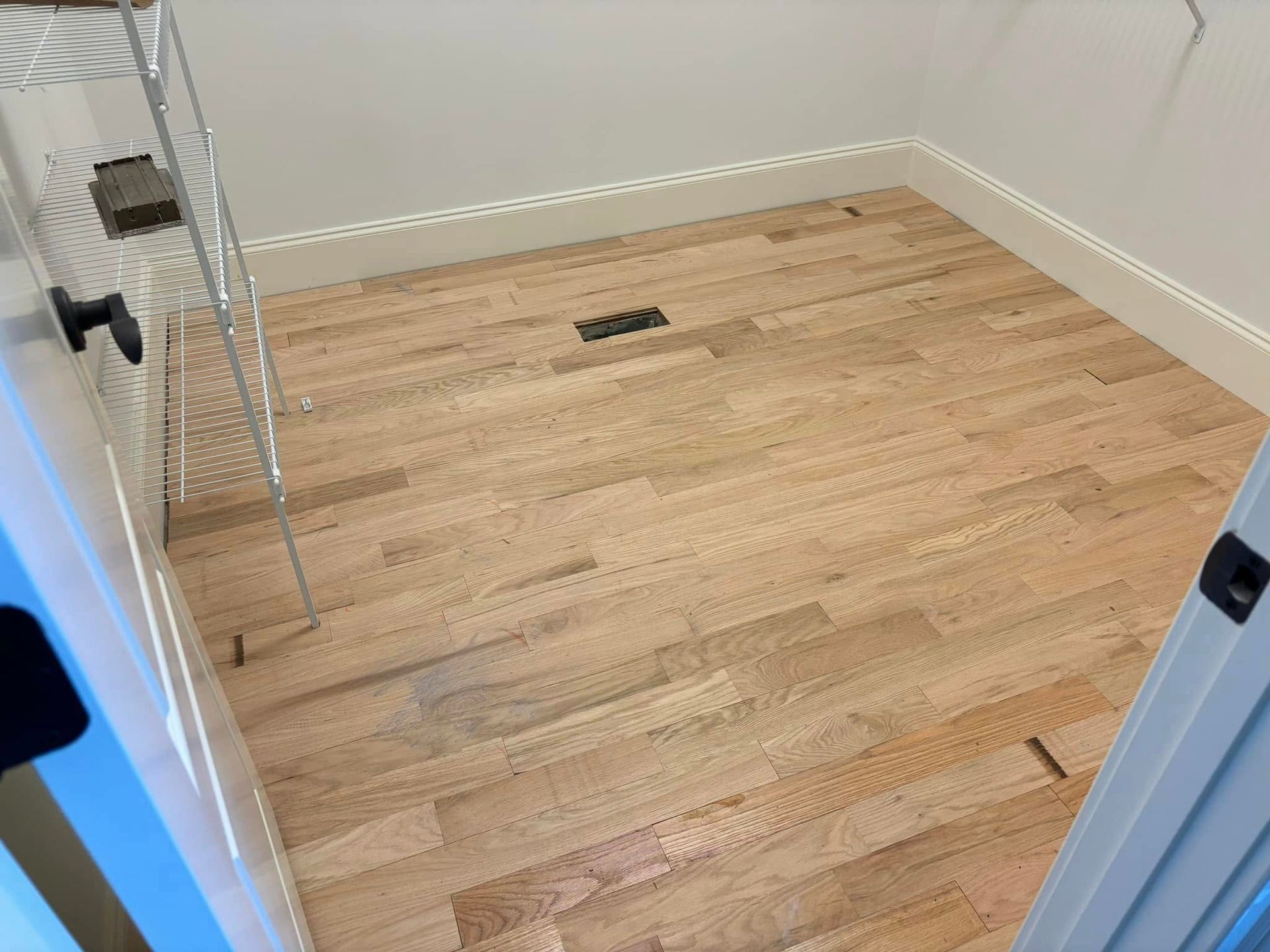 A room with hardwood floors and a ladder in it.