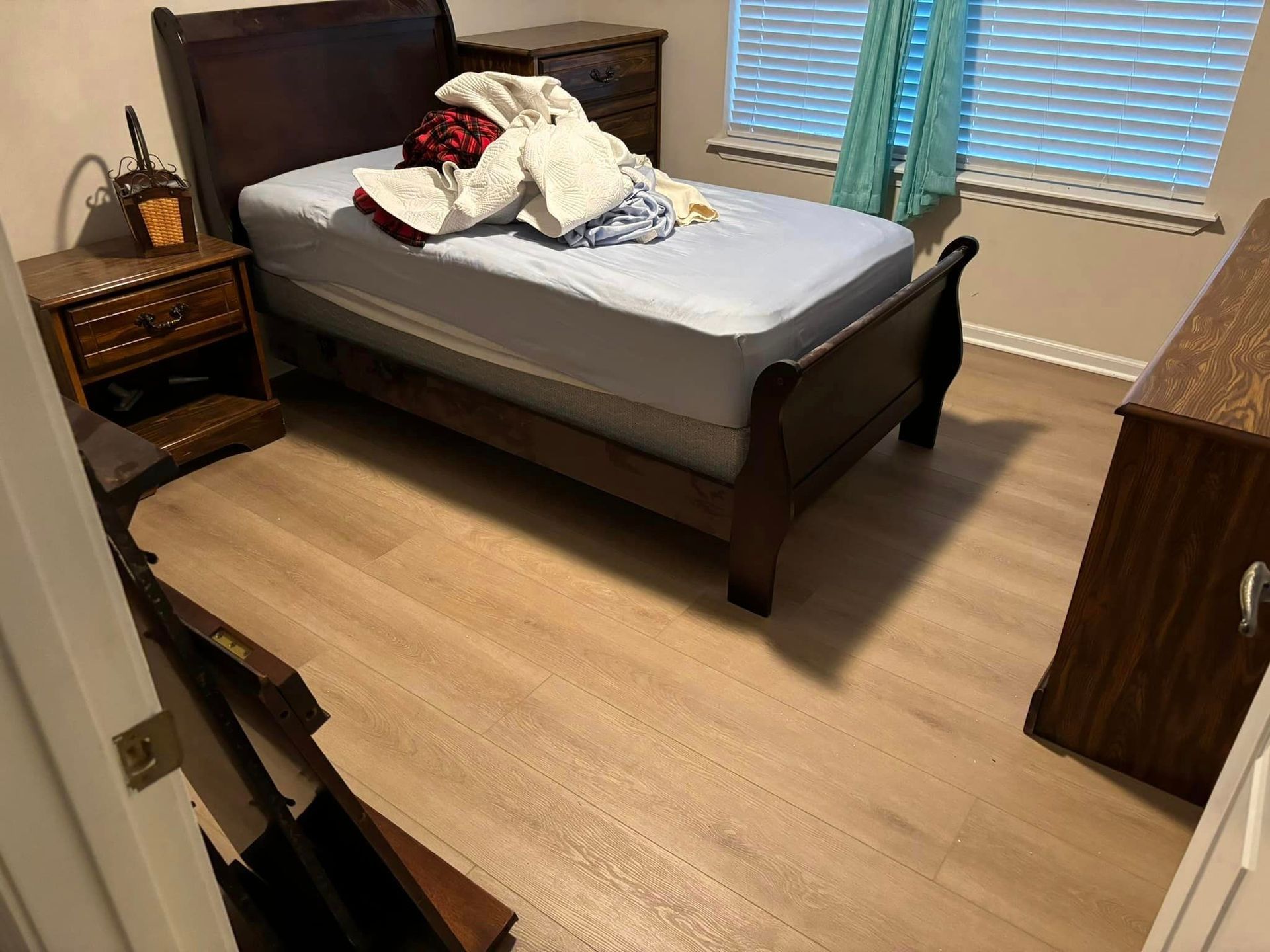 A bedroom with a single bed , nightstand , dresser and window.