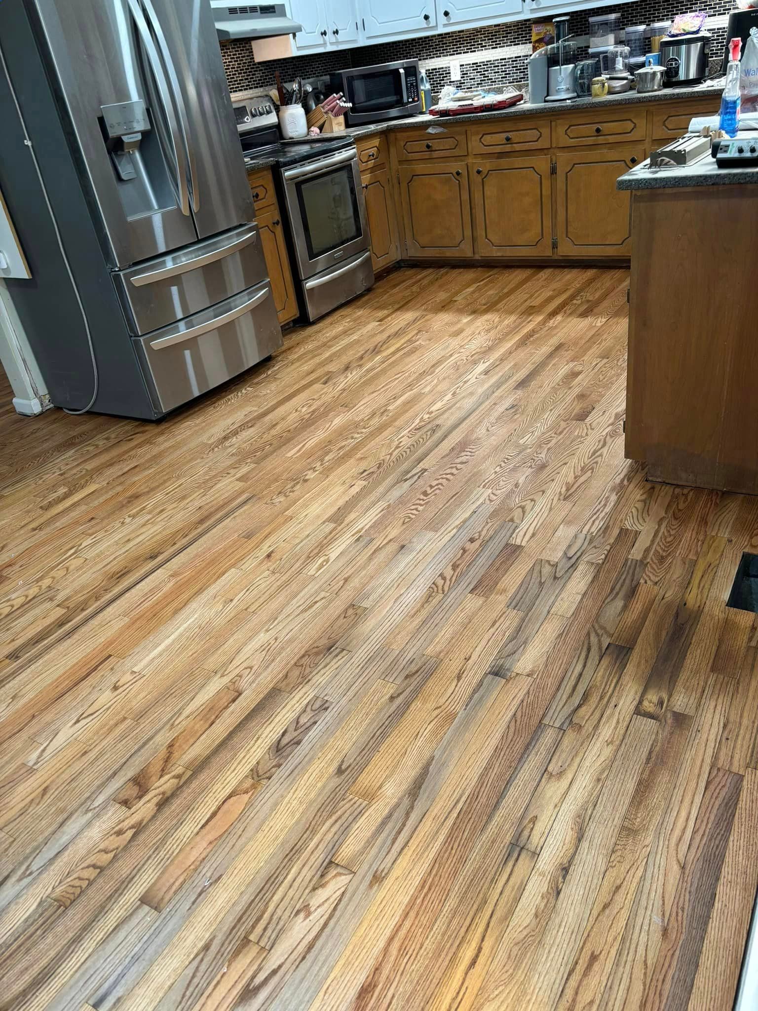 A kitchen with hardwood floors and stainless steel appliances.