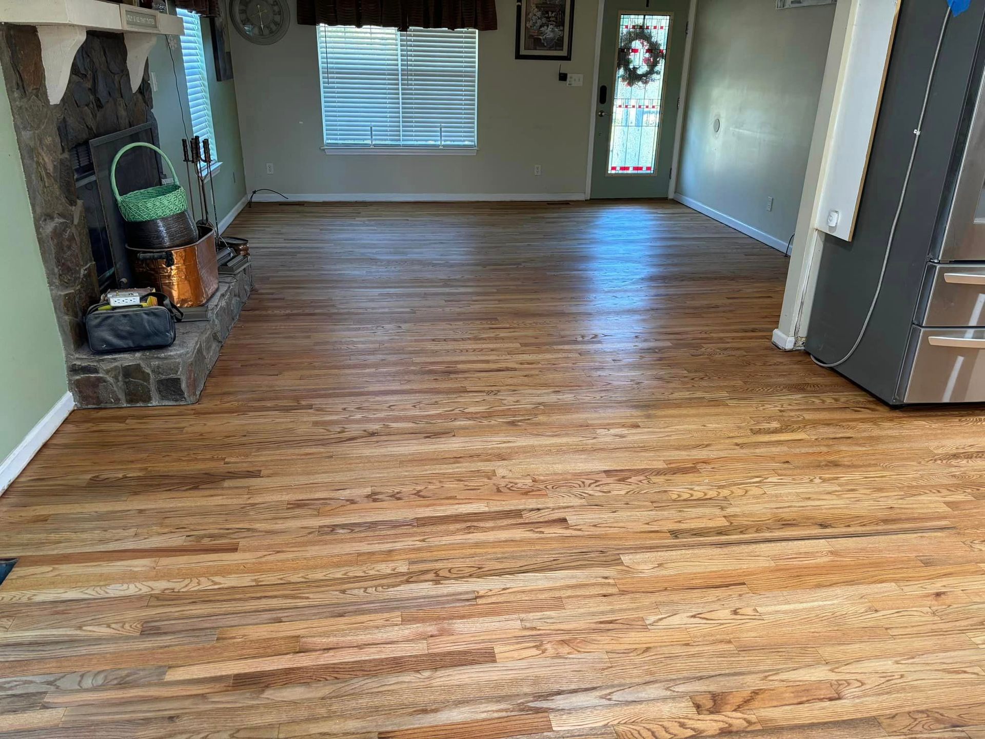A living room with hardwood floors and a fireplace.