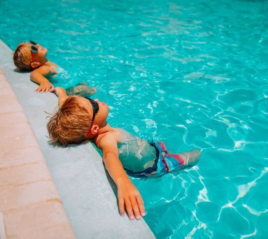 Little boy and girl relax in pool, family on beach resor