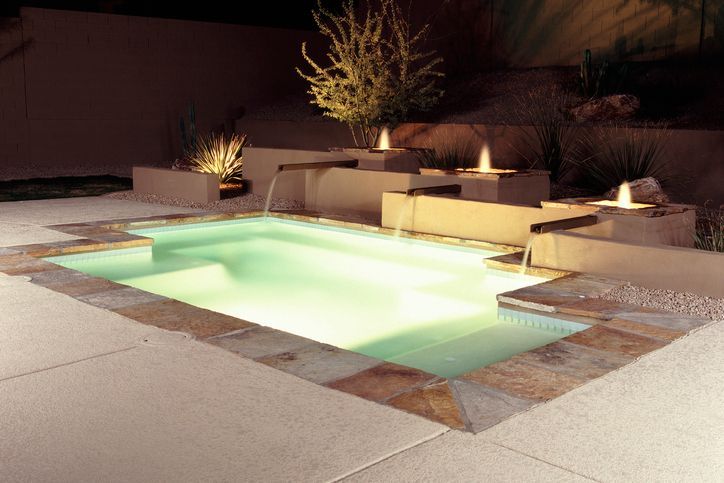 Contemporary swimming pool design on an illuminated patio