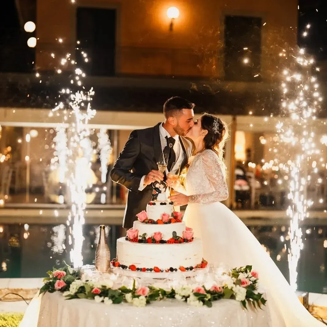 Una sposa e uno sposo che si baciano davanti a una torta nuziale