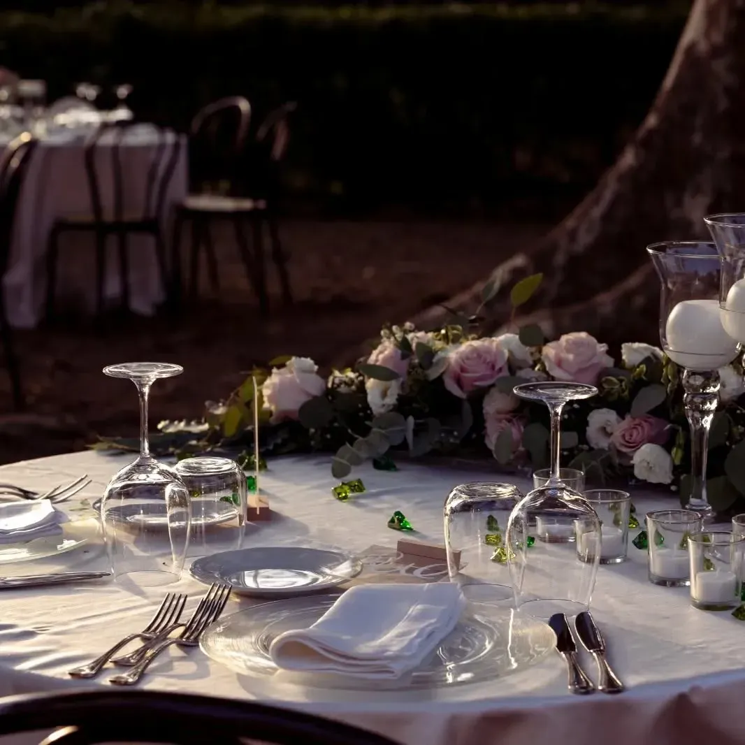 Un tavolo con piatti, bicchieri e fiori sopra