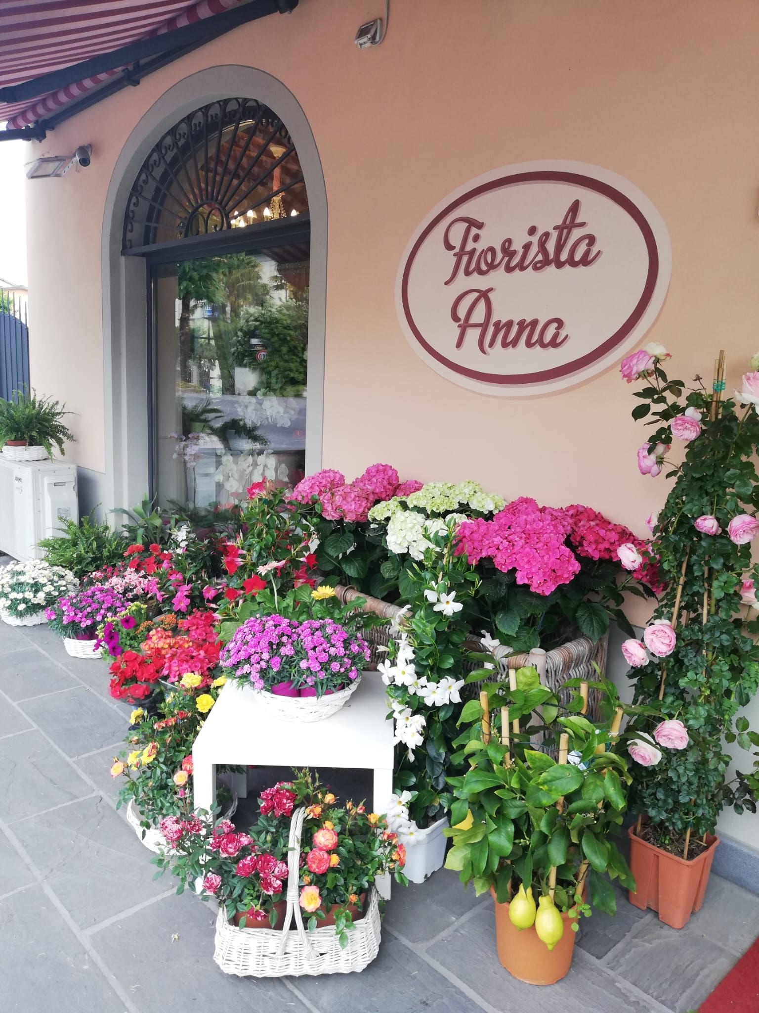 Un negozio di fiori con tanti fiori davanti