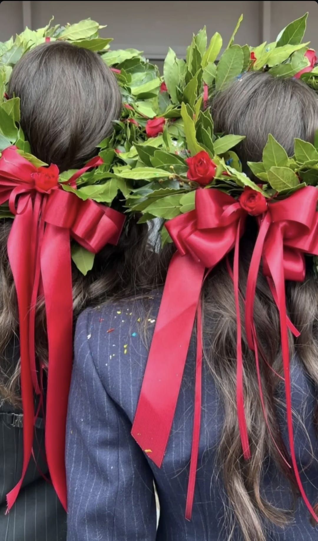 Due donne che indossano corone di fiori con fiocchi rossi tra i capelli.