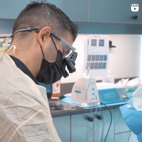 A man wearing a mask and goggles looks down at something