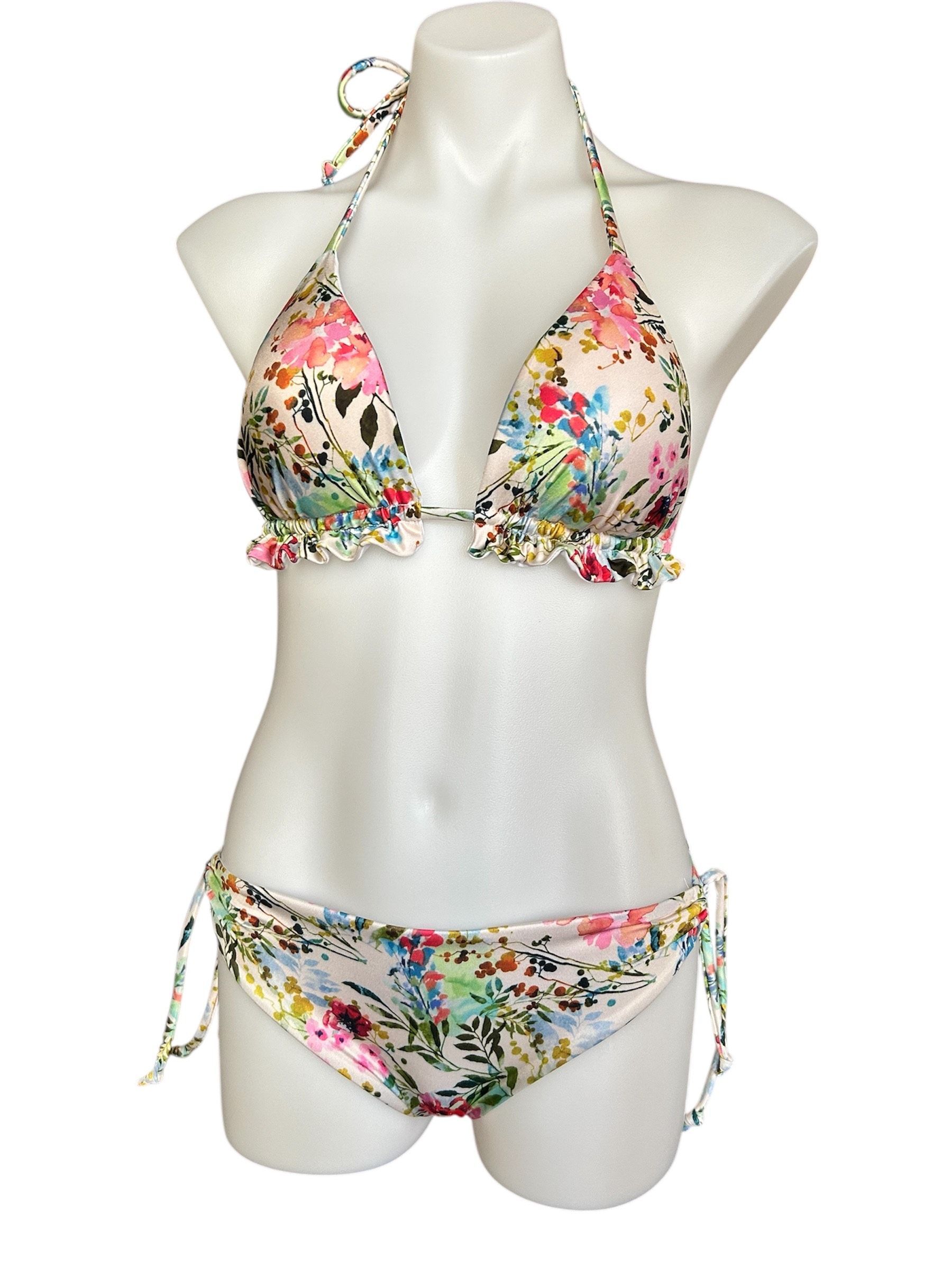 A woman in a bikini is standing on a beach.