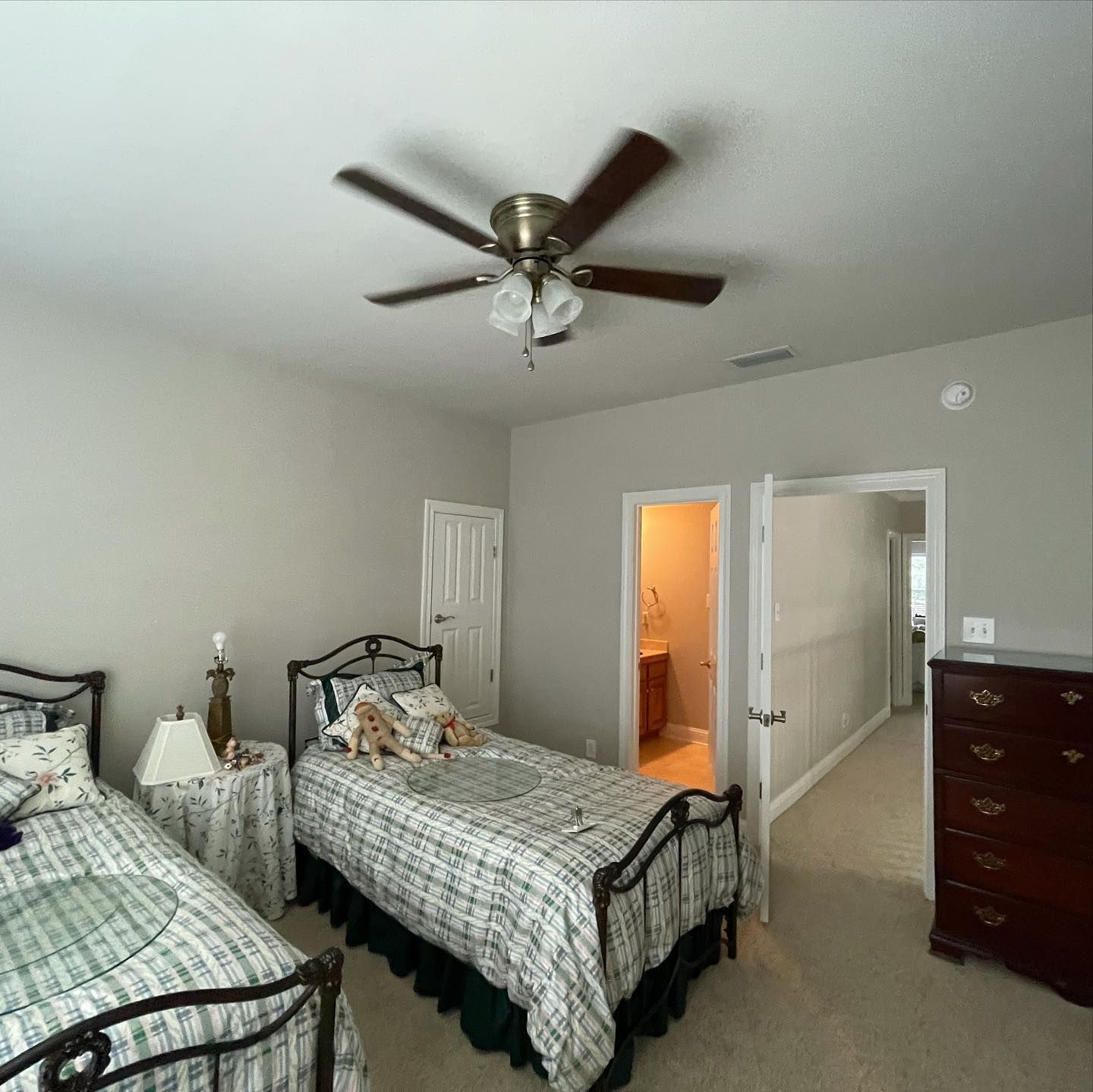 Bedroom with white furniture, green walls, and wood-look flooring.