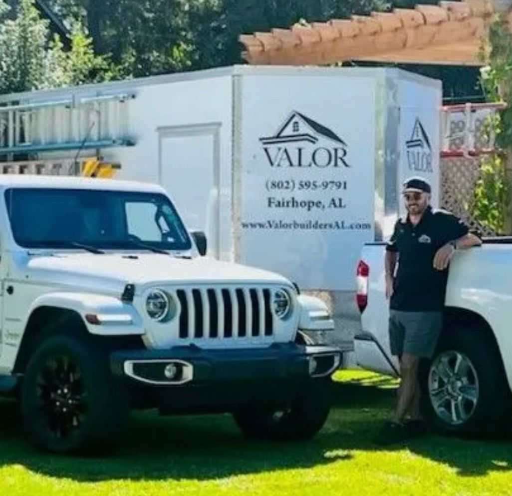 Man in front of white Jeep, truck, and trailer with 