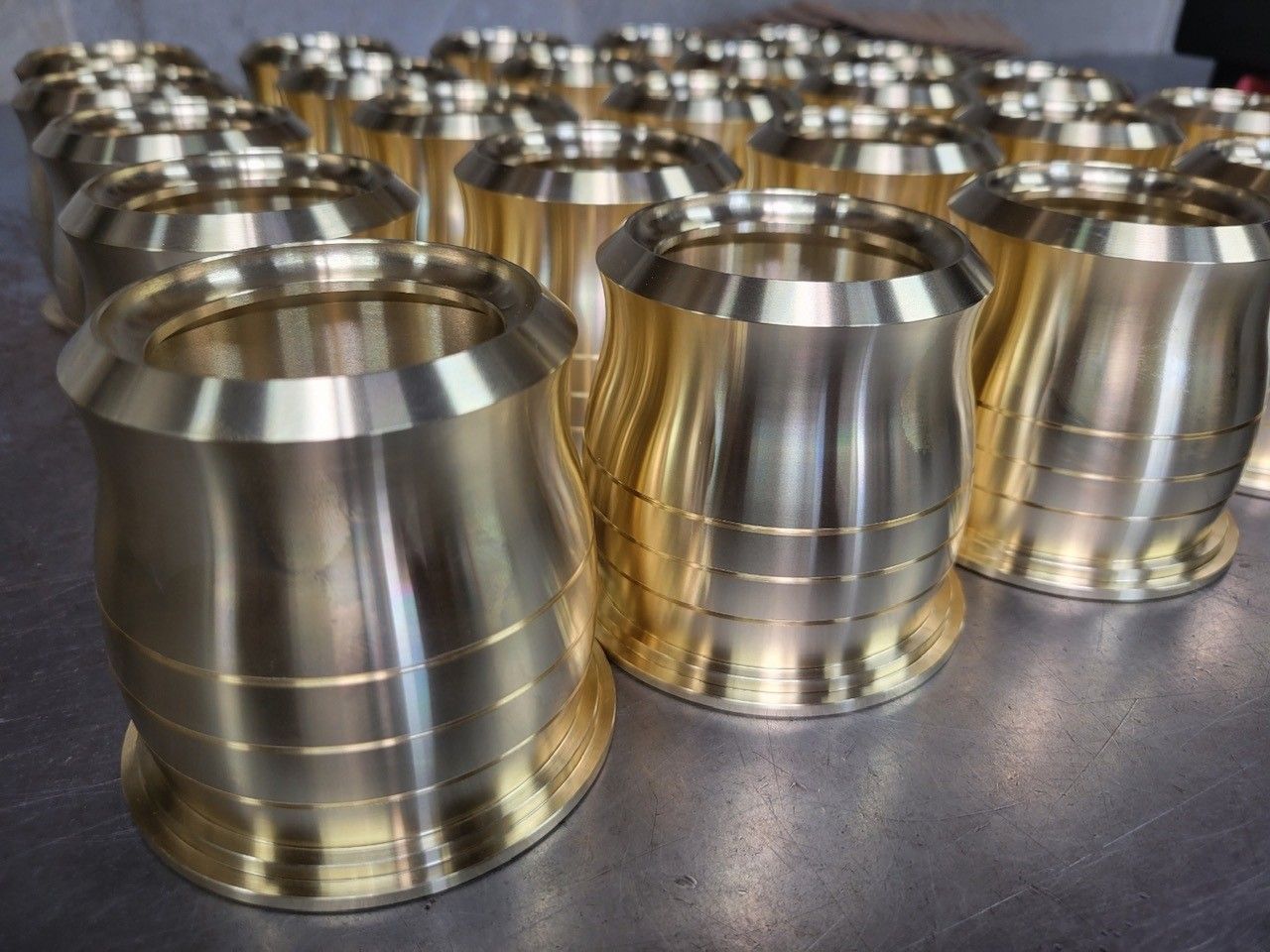A bunch of metal cylinders are lined up on a table.