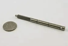 A pen is sitting next to a quarter on a white surface.