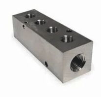 A stainless steel block with holes in it on a white background.