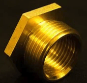 A close up of a brass nut on a black surface.
