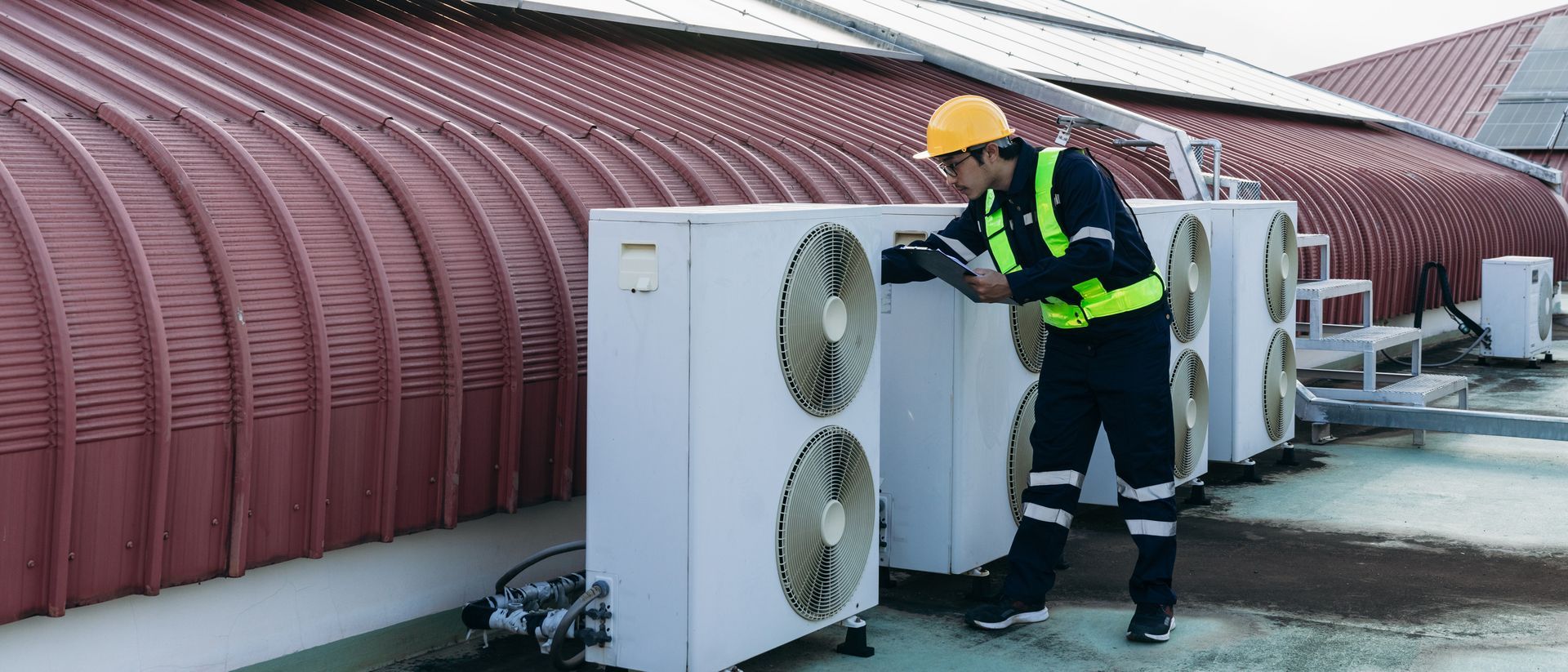 Engineers inspecting the air conditioning cooling system of a large industrial facility.