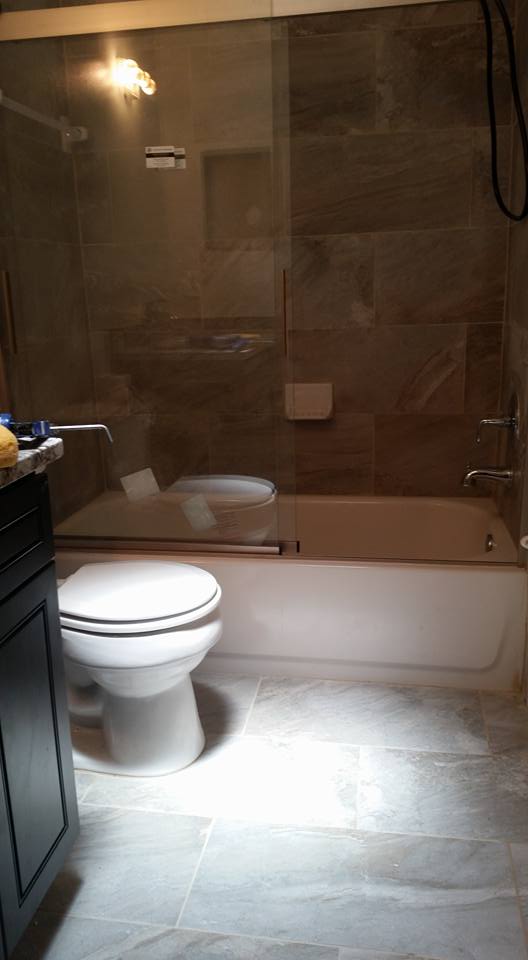 A bathroom with a toilet , sink , tub and shower.