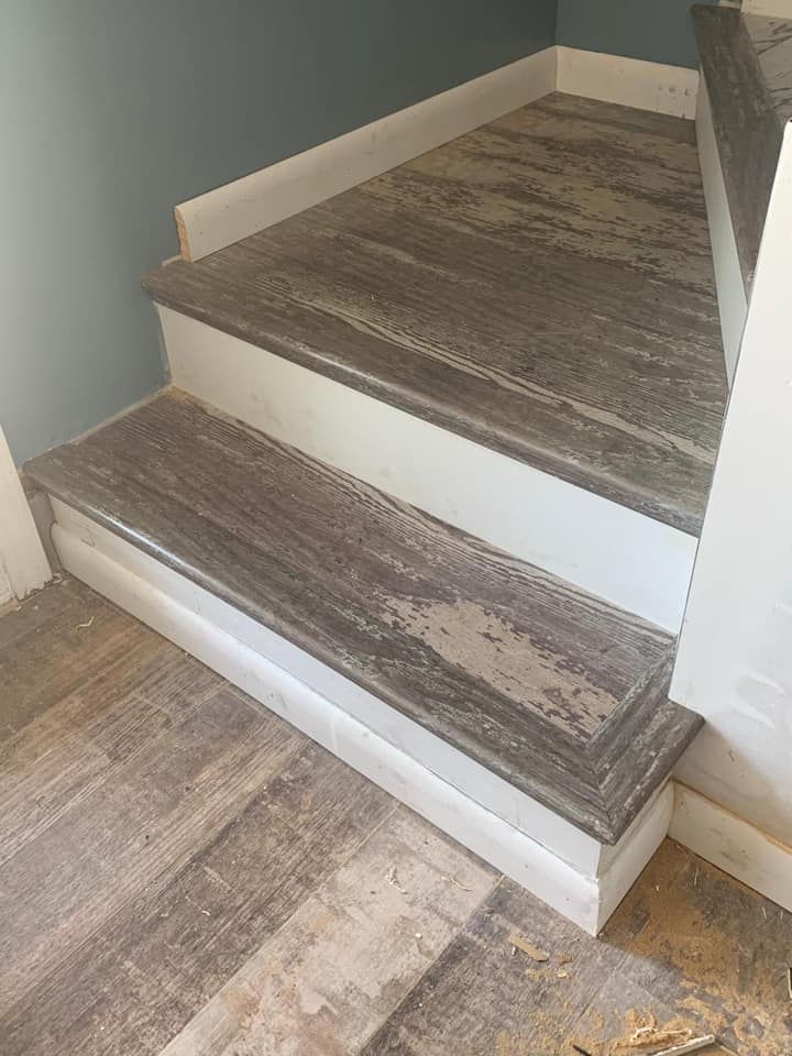 A set of stairs with a wooden floor in a room.