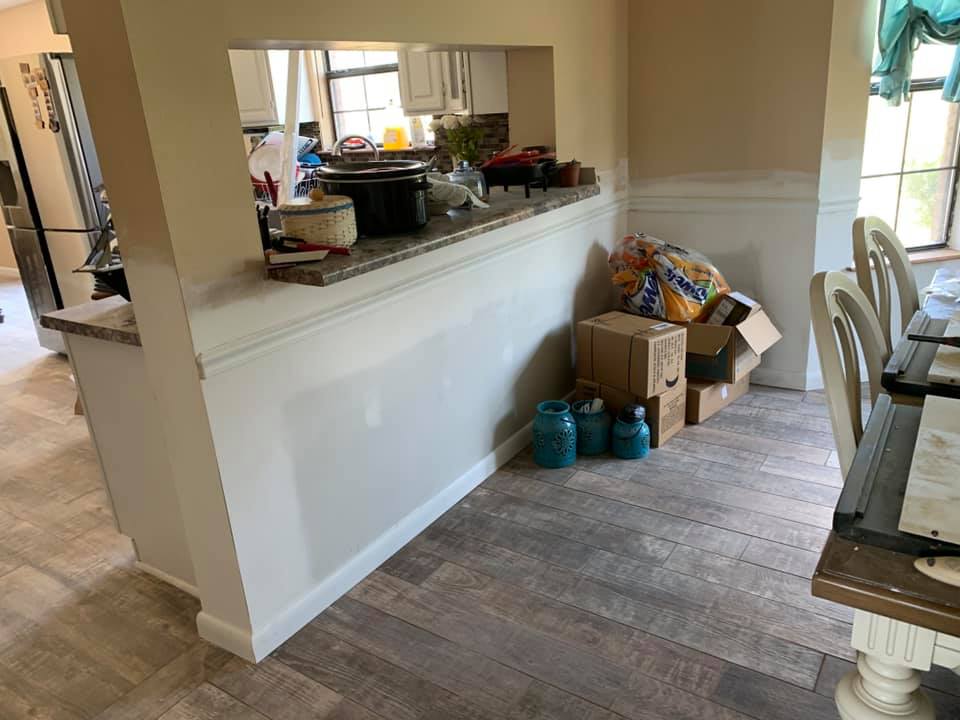 A kitchen with a dining table and chairs and boxes on the floor.
