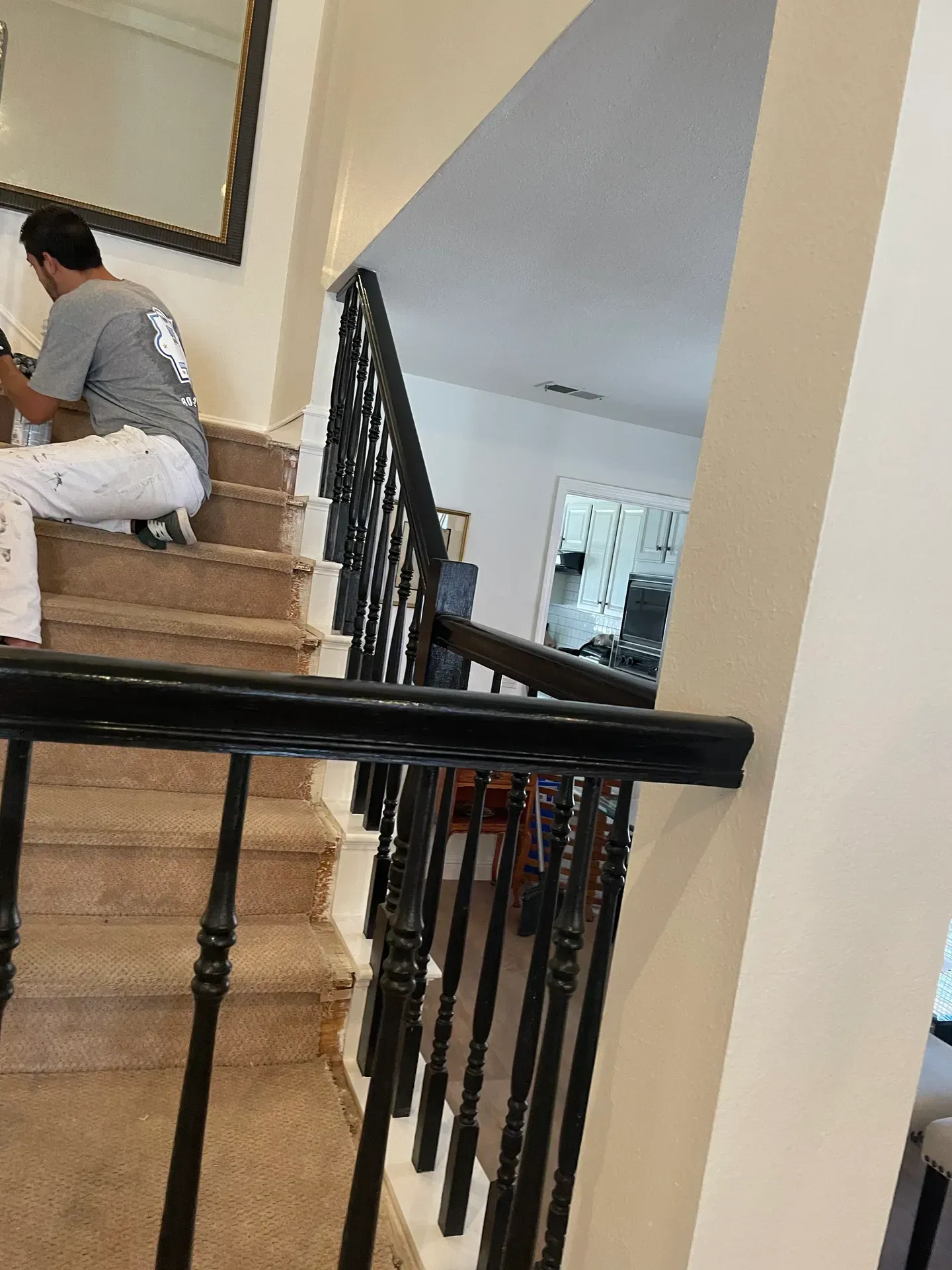 A man is sitting on a set of stairs in a house.