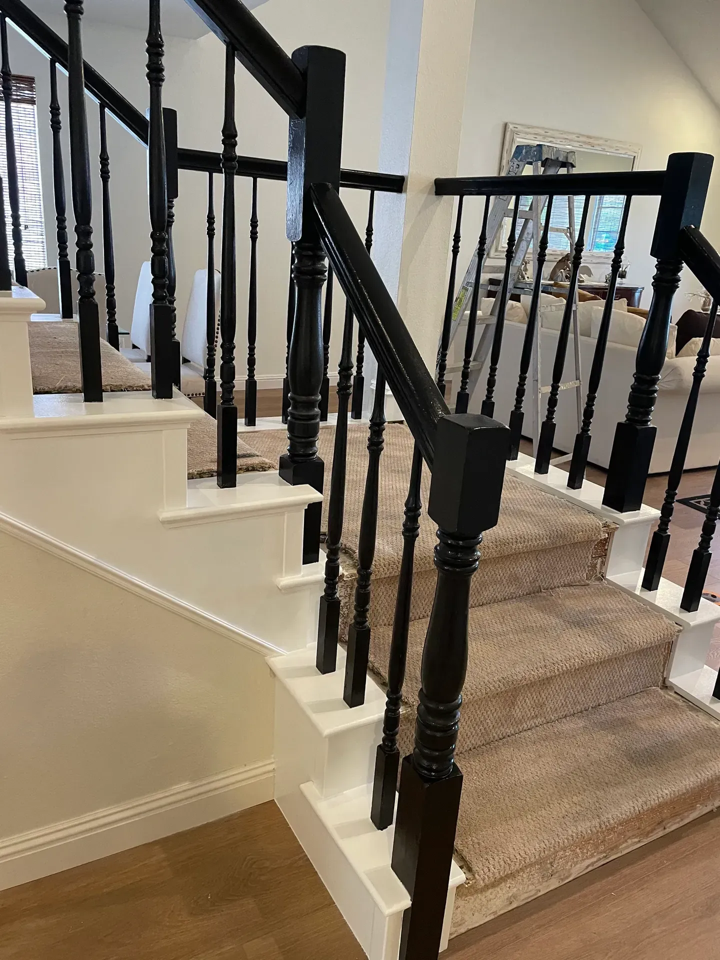 A staircase with black railings and white steps in a house.